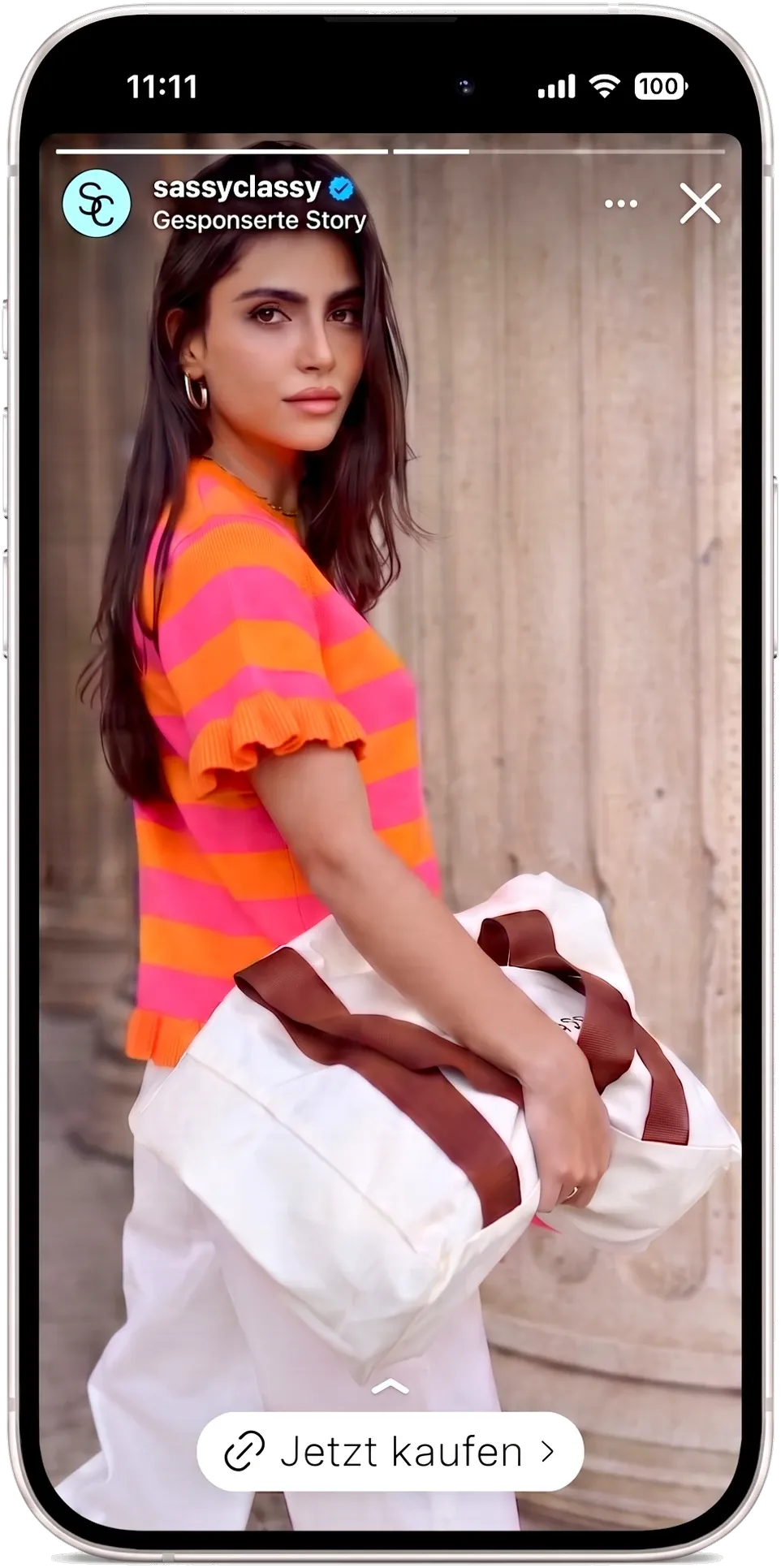 Sponsored Instagram story by SASSYCLASSY on a smartphone: model in a striped knit top with a canvas bag, with a „Jetzt kaufen“ link sticker